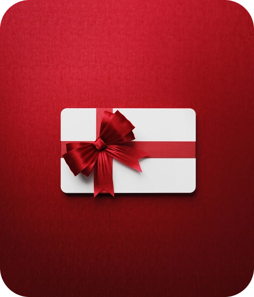 Een witte cadeaubon met een glanzend rood lint en strik staat afgebeeld tegen een dieprode achtergrond met structuur, wat een feestelijke en elegante sfeer uitstraalt.